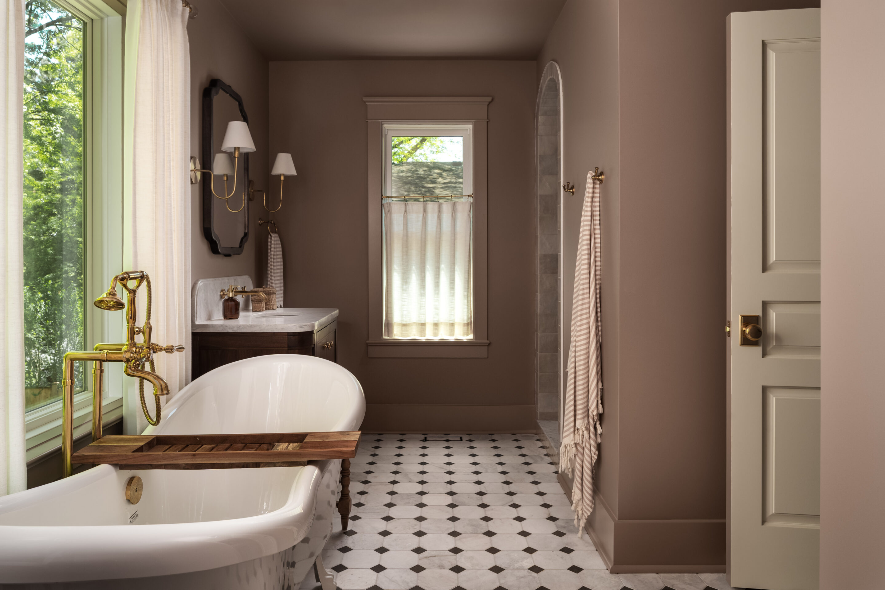 Renovated bathroom with a clawfoot tub and black-and-white tile at Project Bellview