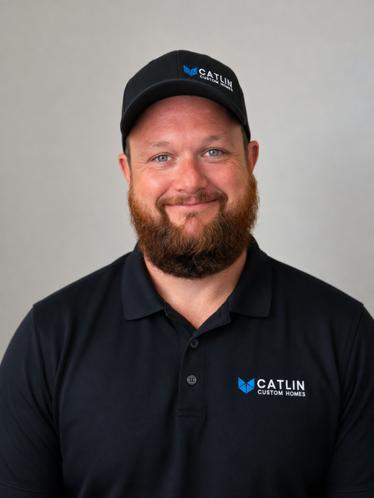 Professional headshot of Mike McManus, Team Supervisor at Catlin Custom Homes, wearing a branded black polo and cap against a neutral background.